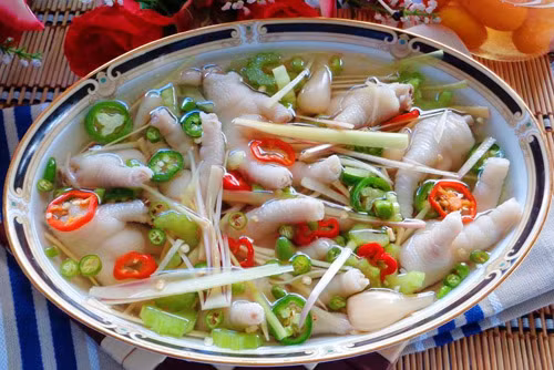 Thay nước khác và luộc tiếp chân gà lần 3. Sau đó vớt chân gà ra ngâm vào tô nước lạnh có đá 3-4 phút rồi rửa thật sạch với nước lạnh. Cho chân gà, ớt, tỏi, kiệu đã rửa sạch vào hũ thủy tinh, sau đó đổ nước giấm đã để nguội vào, đậy nắp kĩ, để nơi thoáng mát 2 ngày là có thể ăn được. Ảnh: phunutoday.vn.