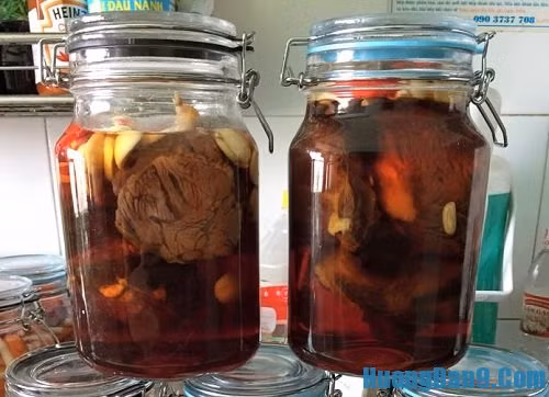 Bắp bò và mắm phải thật nguội bạn mới tiến hành cho vào lọ sạch để ngâm. Sau đó cho bò vào lọ, đổ hỗn hợp mắm pha cho ngập mặt chỗ bắp bò, thả nốt phần tỏi và ớt tươi chuẩn bị vào lọ. Ảnh: huongdan9.com.