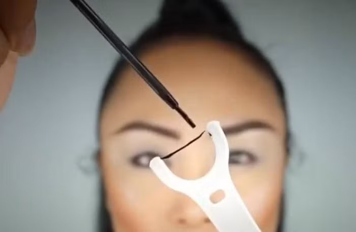 Chỉ nha khoa. Dùng bút kẻ mắt của bạn tô màu lên chỉ nha khoa, lưu ý chỉ nên tô theo chiều dài phần đuôi mắt mà bạn muốn thôi nhé. Tô hết theo thân chỉ sẽ khiến phần đuôi mắt bị dài quá. Áp phần chỉ nha khoa đã được tô màu vào đuôi mắt để tạo thành một đường kẻ sắc nét. Ảnh: Iamsugarcoated.