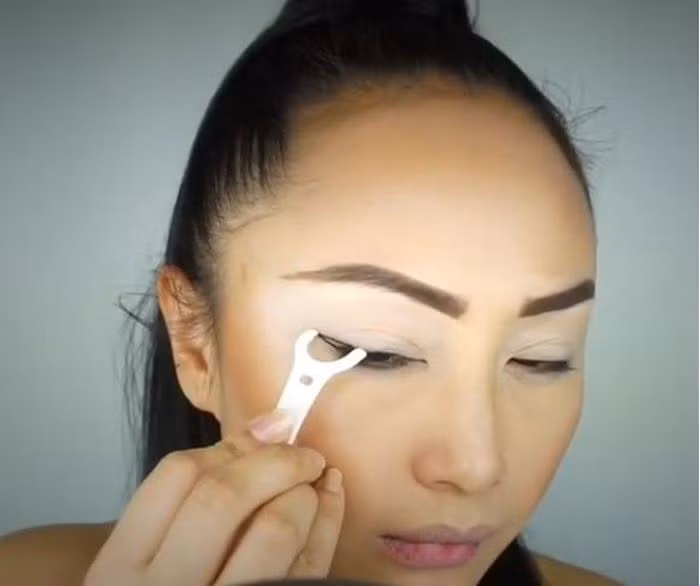 Các bạn lưu ý giữ nguyên chỉ trong khoảng 30s rồi mới thả tay. Lặp lại một lần nữa với mí mắt trên để 2 đường tạo thành một góc nhọn. Bước cuối cùng chính là dùng bút kẻ mắt tô lại 2 đường viền vừa lẽ là xong. Ảnh: Iamsugarcoated.