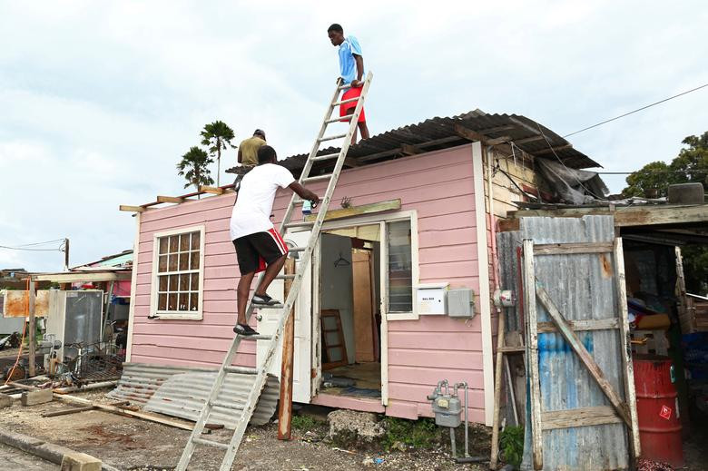 Người dân sửa lại mái nhà bị tốc do gió lớn trong trận bão Elsa ở St. Michael, Barbados, ngày 2/7.