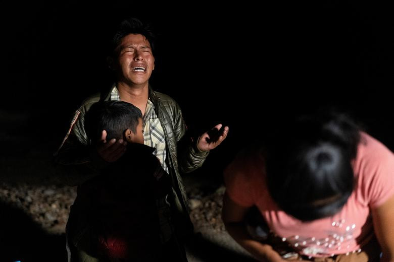 Một số người di cư đến từ Guatemala cầu nguyện sau khi vượt sông Rio Grande từ Mexico vào Mỹ, tại Roma, Texas, ngày 28/7.