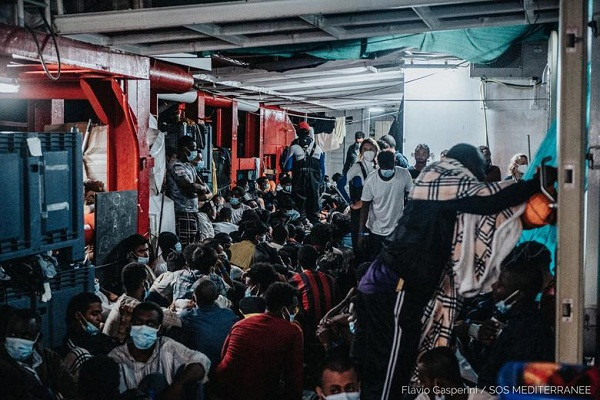 Các di dân đeo khẩu trang đề phòng lây nhiễm virus trên tàu.