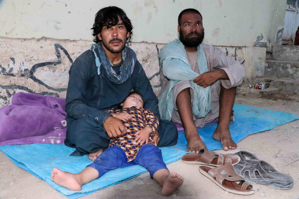 Một số người dân ở Afghanistan trải tạm tấm bạt trên nền đất để ngồi nghỉ. Ảnh: EPA.