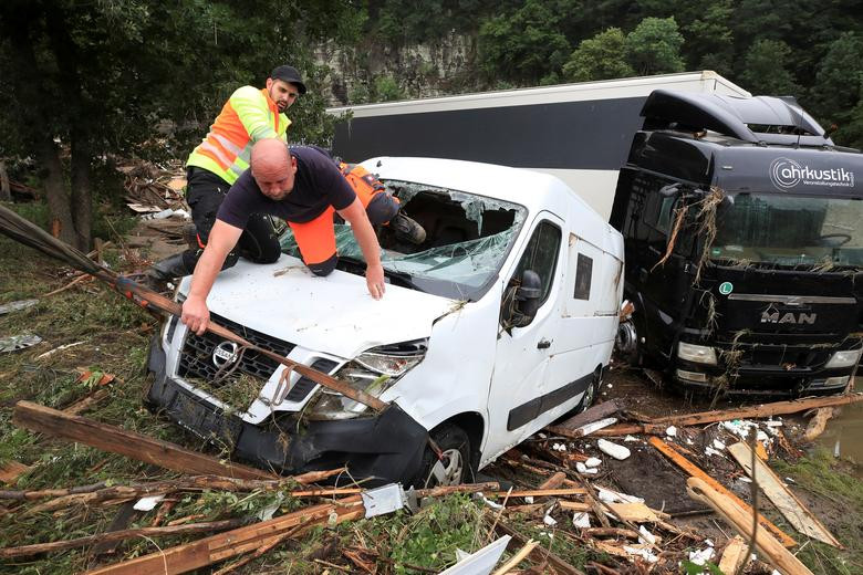 Nhân viên cứu hộ xem xét một chiếc xe tải bị hư hỏng sau trận mưa lớn ở Schuld, Đức, ngày 16/7.
