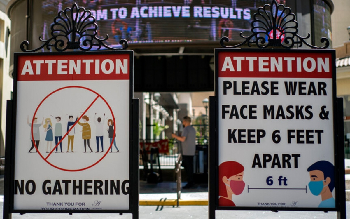 Hôm 22/7, chính quyền Mỹ cho biết đang có kế hoạch mở rộng đối tượng tiêm chủng. Theo đó, nước này cân nhắc đưa trẻ dưới 12 tuổi vào diện tiêm vắc xin phòng COVID-19 vào trước cuối tháng 8 hoặc đầu tháng 9 tới. Ảnh: Biển cảnh báo hãy đeo khẩu trang và giãn cách xã hội để ngừa COVID-19 ở Mỹ. Ảnh: AP.