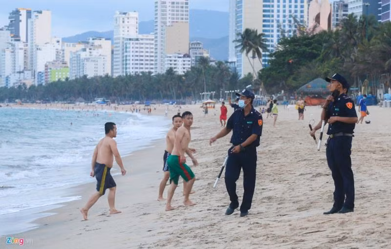 Gần 18h, lực lượng xung kích trật tự thuộc UBND TP Nha Trang có mặt trên bãi biển và yêu cầu mọi người lên bờ, về nhà.