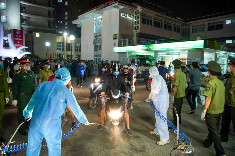 Người di chuyển từ trong bệnh viện ra ngoài, tất cả người và phương tiện được phun xịt khử khuẩn mới được đi ra.