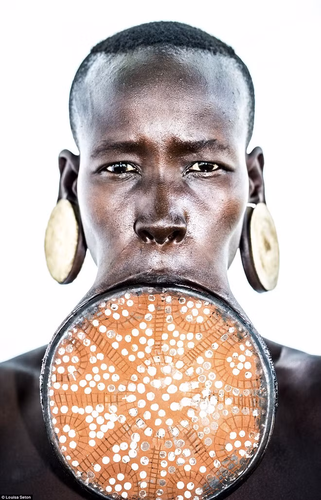 Cụ thể, phụ nữ người Surma thực hiện phong tục căng môi làm đẹp từ xa xưa. Không ai rõ tập tục được thực hiện từ thời điểm nào.