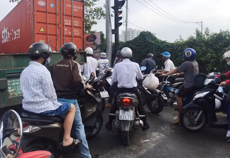 Xe máy chen chúc tìm hướng thoát giữa dòng xe tải, container trong vòng vây kẹt cứng.