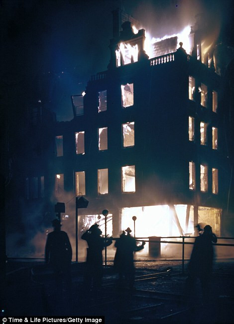 Nhân viên cứu hỏa nỗ lực dập tắt đám cháy xảy ra tại một tòa nhà ở London vì bị máy bay của phát xít Đức rải bom oanh tạc.