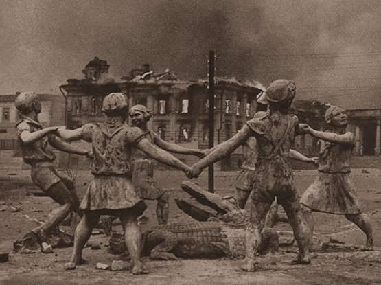 Bức ảnh chụp Barmaley Fountain - một bức tượng gồm 6 đứa trẻ nhảy múa xung quanh một con cá sấu ở Stalingrad, Liên Xô. Sau khi kết thúc trận Stalingrad trong Thế chiến 2, nhiều tòa nhà, đường xá... ở thành phố này bị bom đạn phá hủy hoặc hư hại nặng. Khi xem ảnh, nhiều người đau xót trước những mất mát, đau thương mà con người hứng chịu vì chiến tranh.