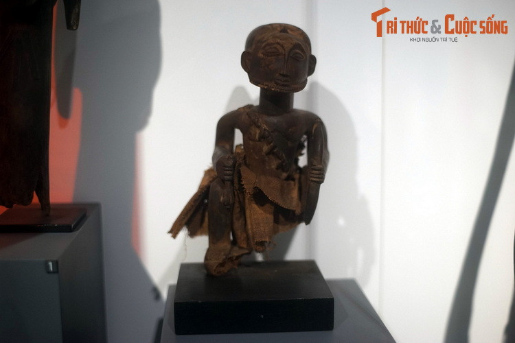 Tượng tổ sư thợ săn của người Hemba, CHDC Congo. Làm từ gỗ và vải sợi thực vật, bức tượng được tạo hình với tay trái cầm cung, tay phải cầm chùy.