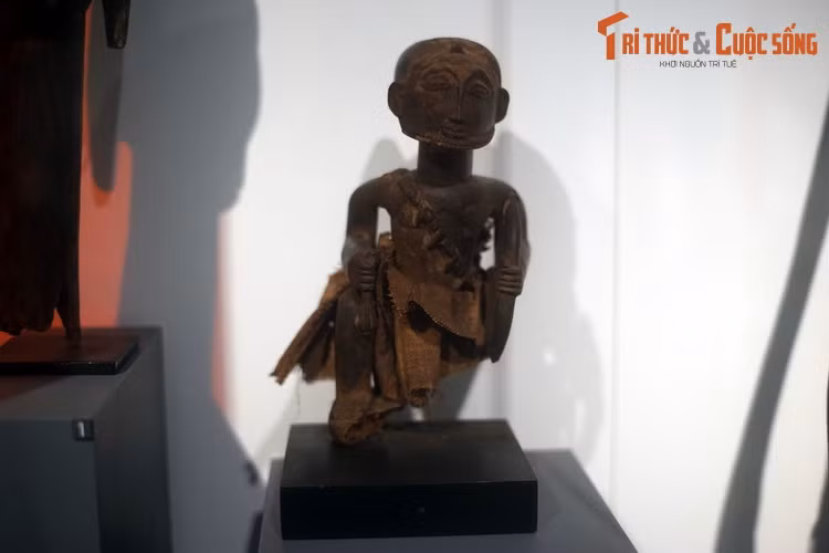 Tượng tổ sư thợ săn của người Hemba, CHDC Congo. Làm từ gỗ và vải sợi thực vật, bức tượng được tạo hình với tay trái cầm cung, tay phải cầm chùy.