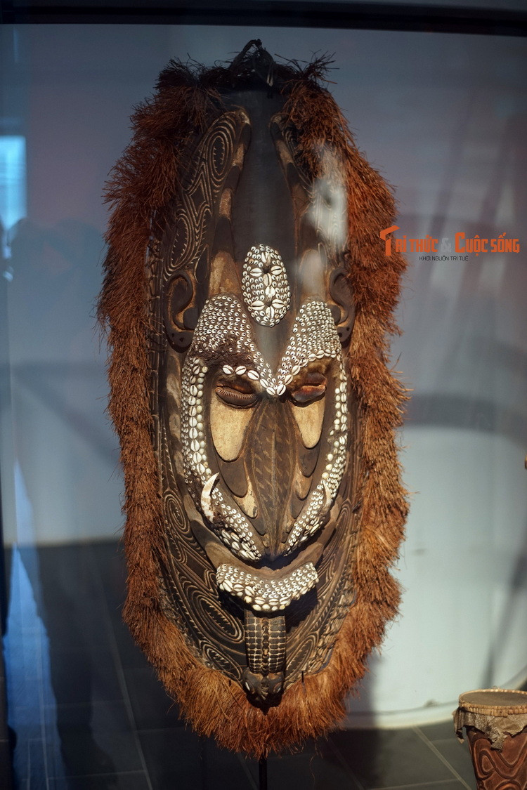 Mặt nạ tổ tiên, làm từ gỗ, xơ cọ, ốc tiền, phẩm màu, vật phẩm lưu giữ trong nhà đàn ông ở vùng trung lưu sông Sepik, Papua New Guinea. Nhà đàn ông có kiến trúc đặc sắc và luôn cao nhất làng, mặt tiền trang trí cầu kỳ.