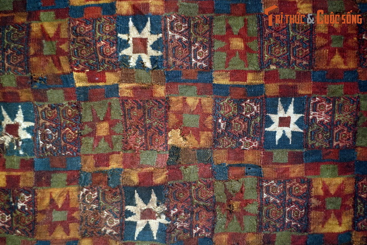 Mảnh tấm choàng làm bằng vải sợi len, hoa văn dệt của văn hóa Chimu (1100-1463). Họa tiết trên vải mô phỏng đầu chùy hình ngôi sao đặc trưng của văn hóa Inca (1450-1532). Những họa tiết nhỏ là mô-típ Chimu truyền thống. Đồ vải của người Chimu thường được cài lông chim và đáp vàng.