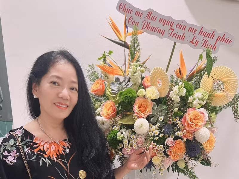 Mẹ chồng của Phương Trinh Jolie nhận hoa từ hai con.