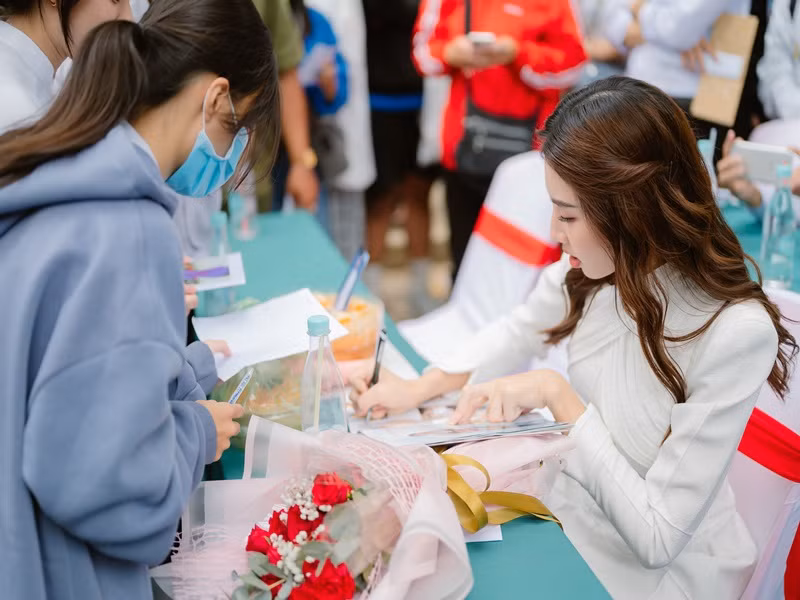 Thùy Tiên vui vẻ ký tặng các em học sinh.