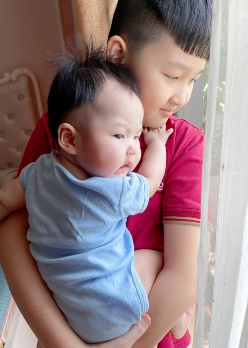 Bé NaNu ôm chặt lấy anh trai.