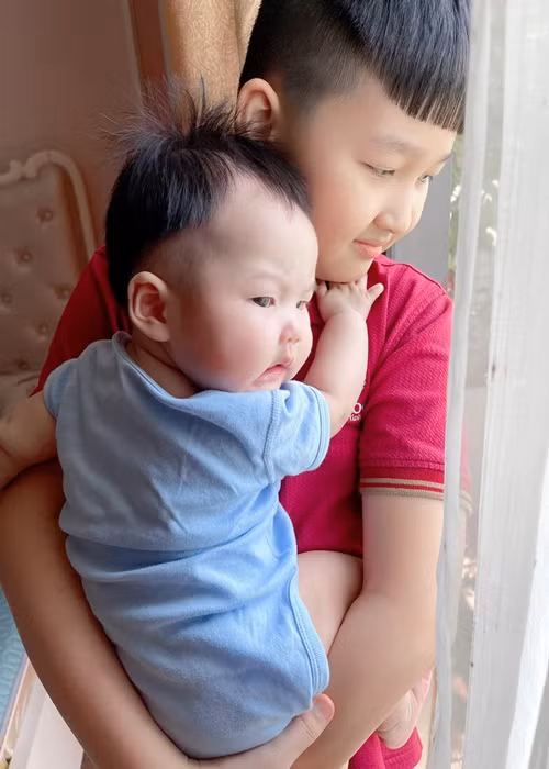 Bé NaNu ôm chặt lấy anh trai.