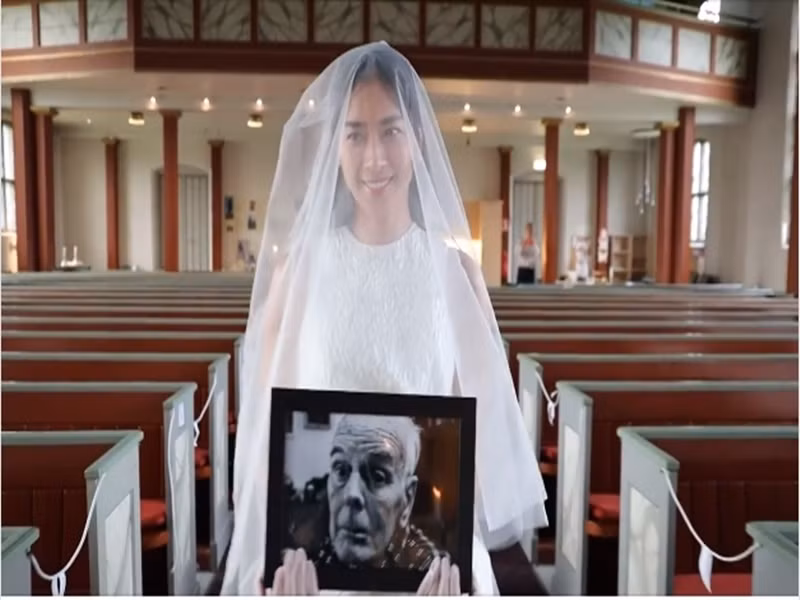 Ngô Thanh Vân ôm di ảnh cha nuôi bước vào thánh đường. Ảnh: Dân Việt