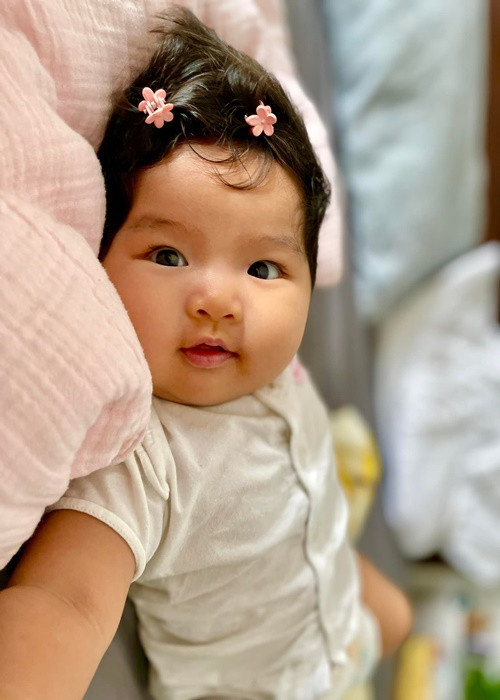 Lê Bê La kẹp lên mái tóc đen của bé Bình An những chiếc kẹp bông hoa nhỏ nhắn.