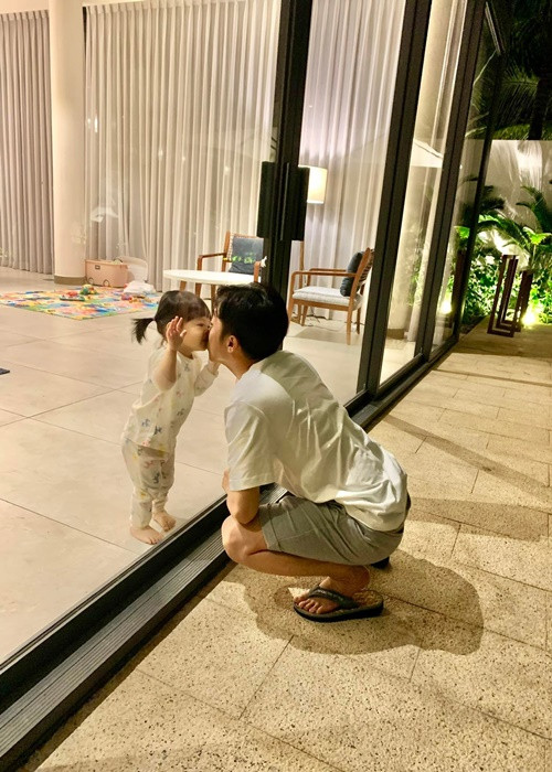 "Đã yêu rồi thì .. bất chấp luôn", ông xã của Cường Đô la chú thích cho khoảnh khắc hôn con gái qua kính.