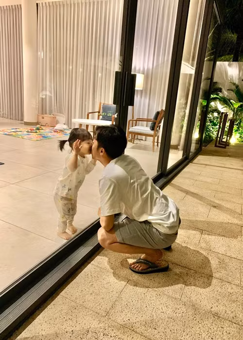 "Đã yêu rồi thì .. bất chấp luôn", ông xã của Cường Đô la chú thích cho khoảnh khắc hôn con gái qua kính.