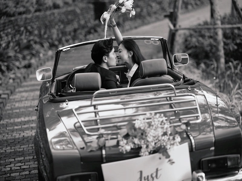 Cặp đôi đi xe mui trần đến địa điểm tổ chức đám cưới.