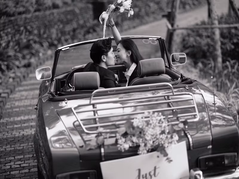 Cặp đôi đi xe mui trần đến địa điểm tổ chức đám cưới.
