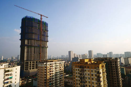 Cảnh thi công tấp nập tại các công trường cho thấy sự phục hồi của thị trường địa ốc và đem lại niềm vui cho người mua nhà. Tuy nhiên, đi cùng với niềm vui của thị trường địa ốc và những người mua nhà, là những nỗi lo về tắc đường, tai nạn lao động mà công trường thi công nhiều dự án bất động sản mang lại. Trong ảnh là chiếc cần cẩu khổng lồ cao vượt so với các tòa chung cư nhiều tầng tại đường Cầu Giấy.