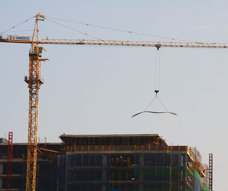 Cần cẩu của một công trình xây dựng trên đường Nguyễn Chánh đang nâng một bó thép với bê tông làm đối trọng phía sau khiến nhiều người cảm thấy ái ngại.