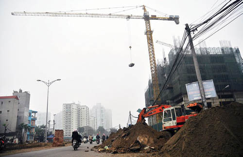 Thùng vật liệu xây dựng lơ lửng giữa đường khi cẩu tháp này hoạt động trên đầu người tham gia giao thông.