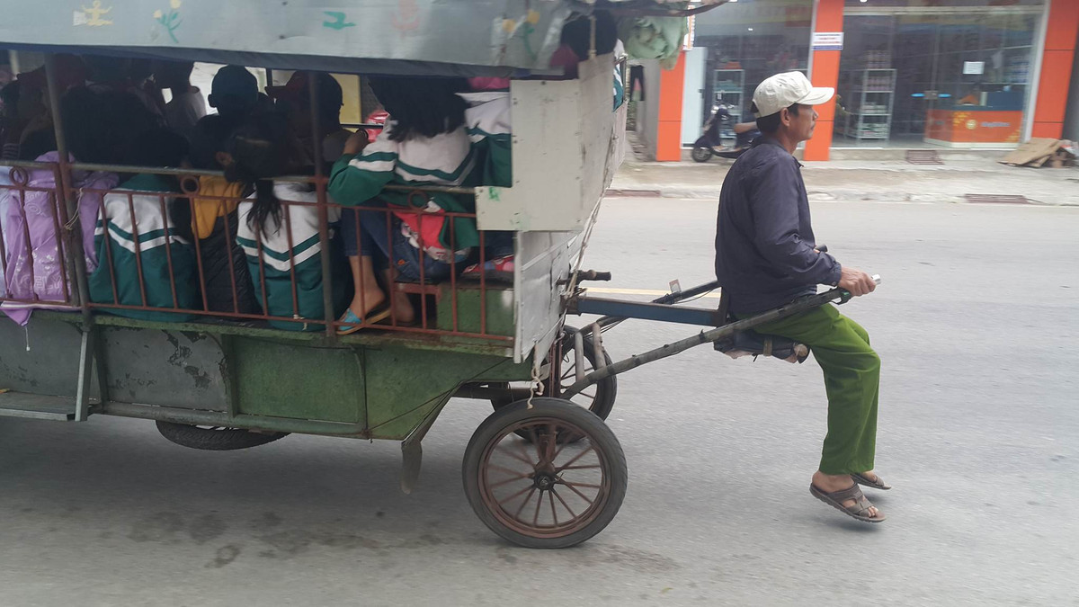 Chiếc xe tự chế "quái dị" khi thiết kế hai tay lái giống kiểu xe kéo và một chiếc ghế đặt giữa cho người điều khiển vô tư ngồi lái chuyên chở hàng chục học sinh tiểu học đến trường.