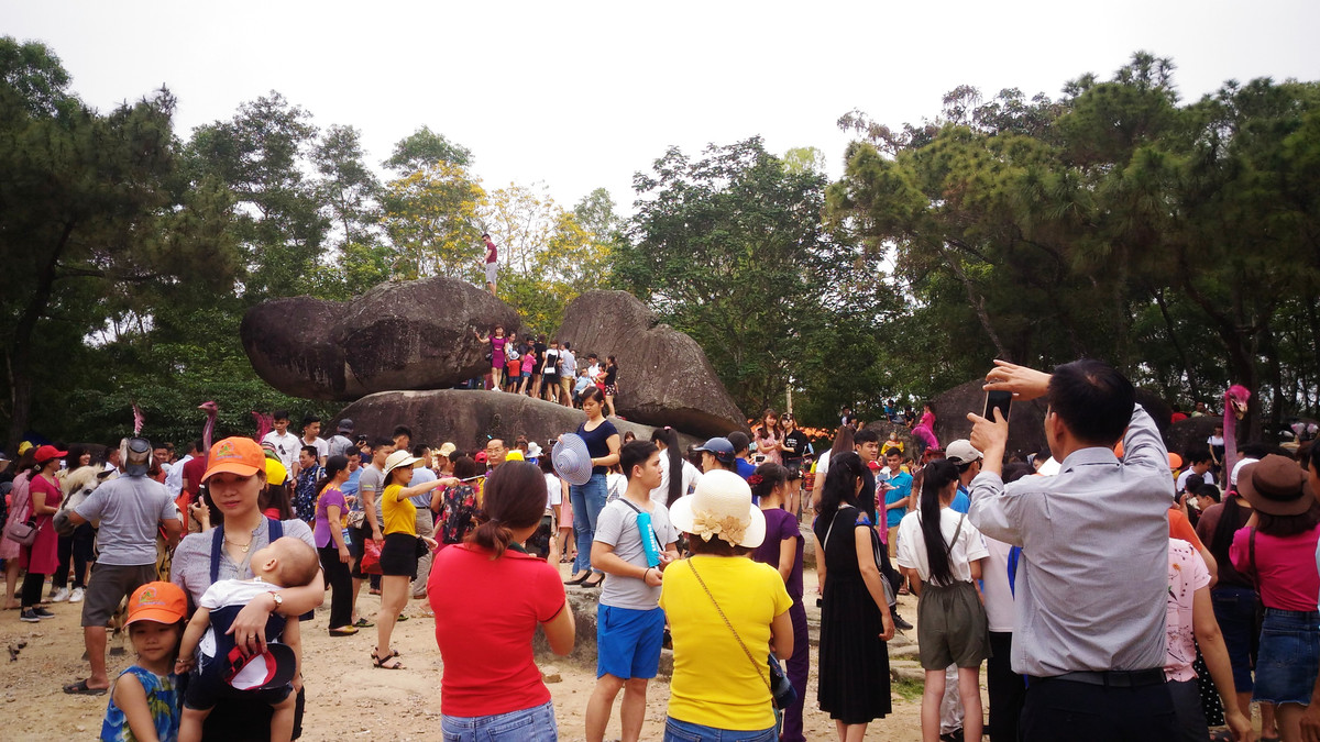 Không chỉ tắm biển, các điểm du lịch quanh các bãi tắm cũng thu hút đông đảo du khách vãn cảnh. Trong ảnh, người dân chen chúc nhau leo lên hòn trống mái ở Sầm Sơn, Thanh Hóa chụp ảnh.