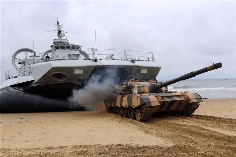 Trong ảnh, xe tăng chủ lực Type 90-II rời “bụng” tàu đổ bộ đệm khí lớn nhất thế giới mà Trung Quốc sở hữu. Một chiếc Zubr có khả năng chở tối đa 3 xe tăng chủ lực (tải trọng 150 tấn).