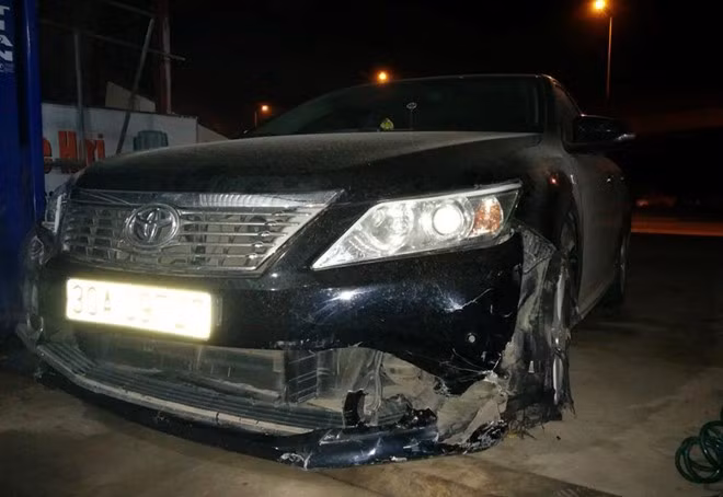 Xe Camry vỡ phần đầu nơi chiếc xe máy bị mắc kẹt. Ảnh: B.T.
