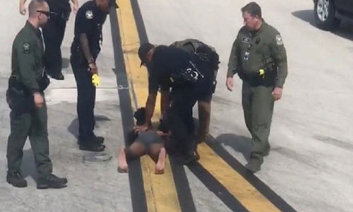 Anh chàng leo cánh máy bay đập cửa sổ bị cảnh sát sân bay trấn áp.