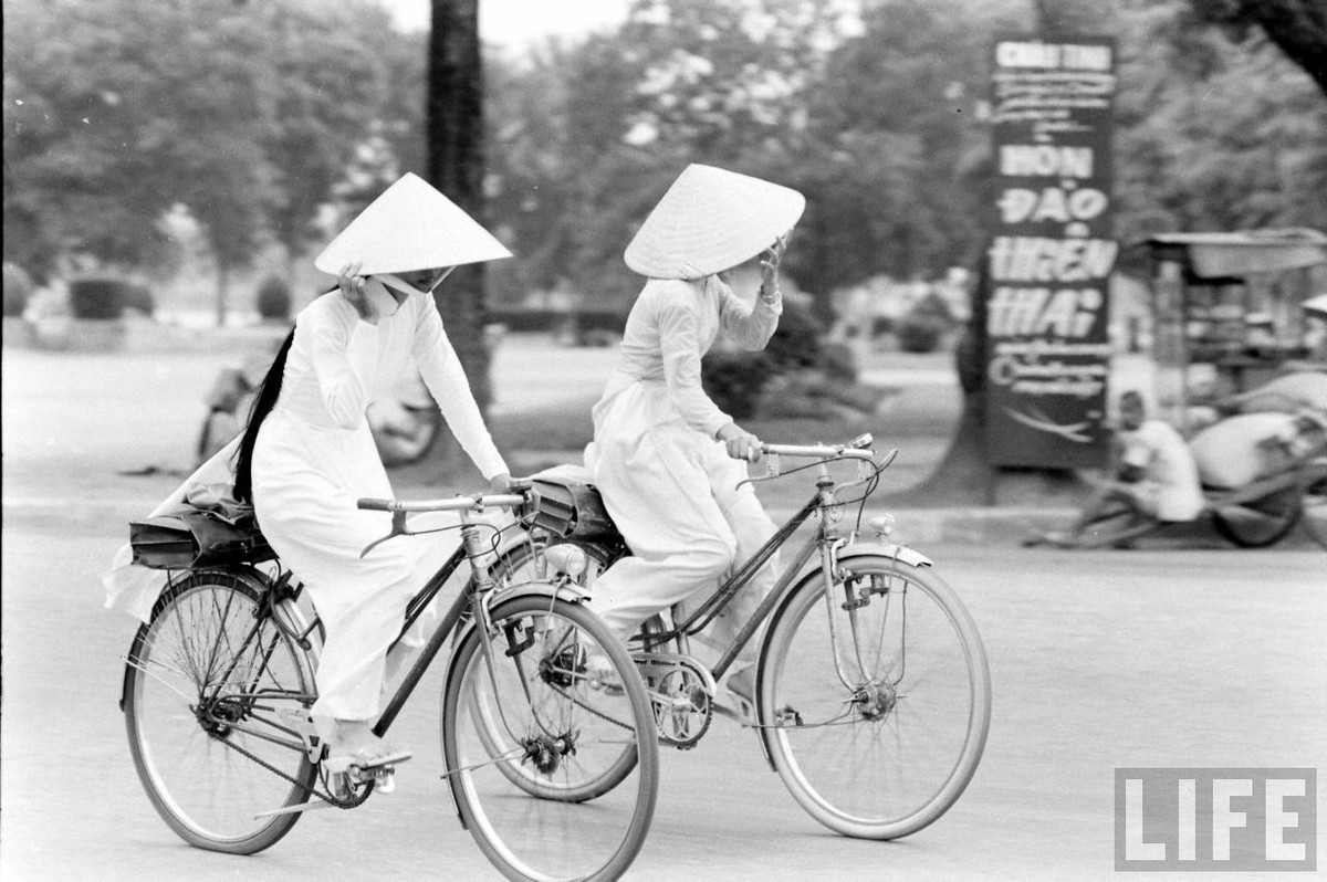 Hai cô gái Huế bẽn lẽn lấy nón che mặt khi bị chụp hình. Ảnh: Life.