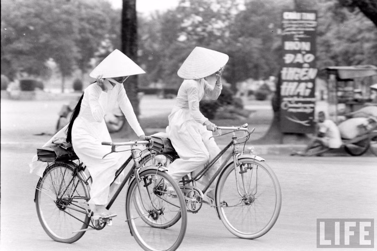 Hai cô gái Huế bẽn lẽn lấy nón che mặt khi bị chụp hình. Ảnh: Life.