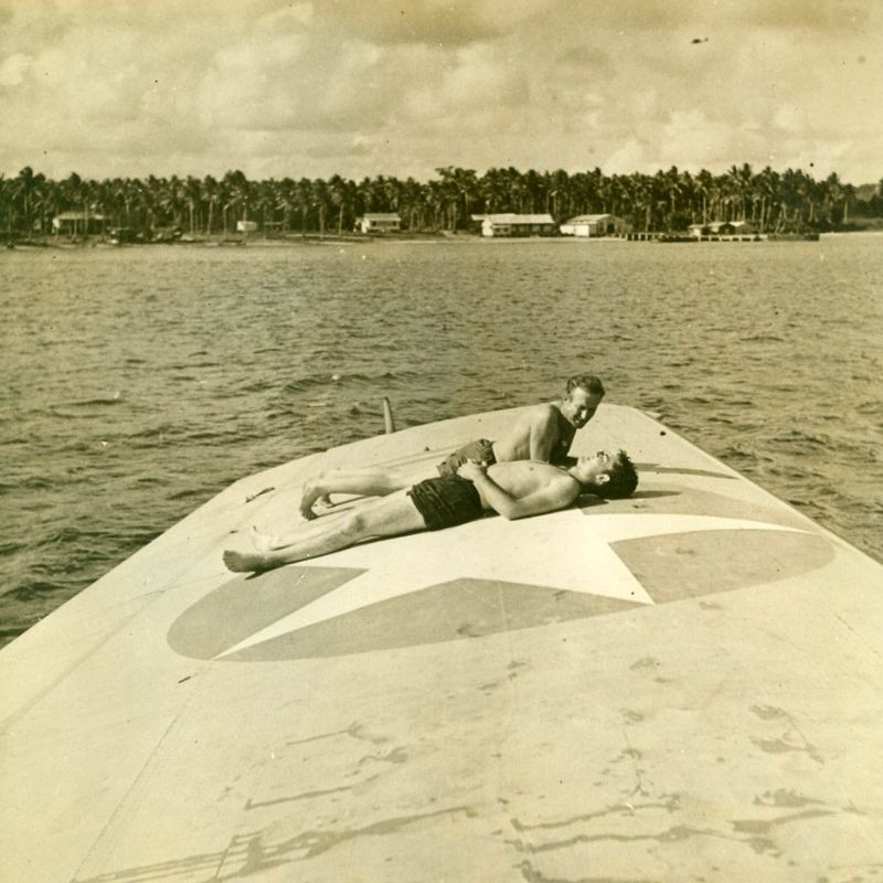 Hai binh sĩ Mỹ tắm nắng trên cánh chiếc thủy phi cơ. Ảnh: MacArthur Museum.