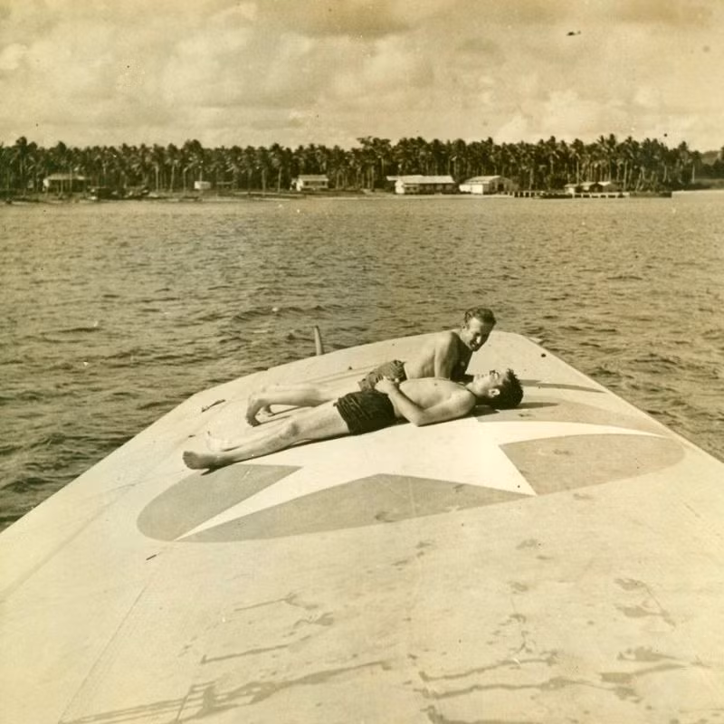 Hai binh sĩ Mỹ tắm nắng trên cánh chiếc thủy phi cơ. Ảnh: MacArthur Museum.