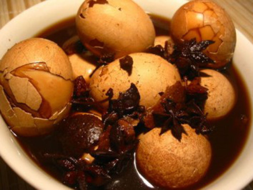 Trứng trà. Theo quan niệm của người Trung Quốc, trứng trà là món ăn mang lại sự thịnh vượng, giàu có trong dịp Tết. Trứng luộc xong rửa sạch trong nước lạnh rồi dùng muôi đập nhẹ để vỏ trứng dập xung quanh. Sau đó cho trứng vào trong một chảo cùng trà đen, xì dầu, ngũ vị hương, hoa hồi, hành lá, gừng đun sôi lăn tăn trong 1 giờ. Ảnh: vietnamchefs