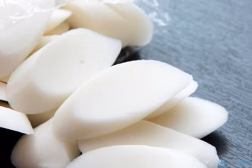 Cho nước hầm thịt vào nồi, nấu sôi với lửa to trong 5 phút. Khi nước sôi, thêm bánh gạo sắt lát vào đun thêm 3 phút nữa. Ảnh: timdeal