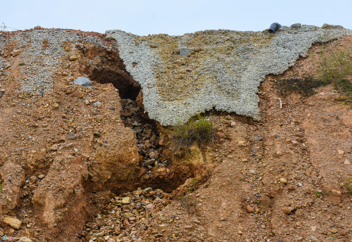 Lớp bê tông mỏng nham nhở bên điểm sạt trượt gần mặt cầu vượt nối vòng xoay cao tốc với đường Trì Bình - Dung Quất. Kỹ sư cầu đường Nguyễn Văn Tuấn (ngụ Quảng Ngãi) cho hay trong trường hợp công trình ở đường nhánh nối vòng xoay cao tốc với đường Trì Bình - Dung Quất lún kéo dài trên nền đất yếu đắp cao 14 m, với độ lún hơn 1 m như đại diện VEC xác nhận, thì dù gia tải 300 ngày vẫn chưa thể xử lý dứt điểm sụt lún. Nhà thầu phải liên tục bù phụ mặt đường nhiều năm sau đó, nhất là đoạn giáp cầu để xe chạy êm thuận.