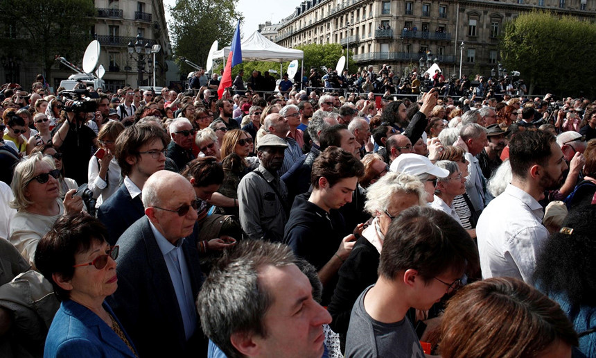 Mọi người tập trung bên ngoài tòa thị chính để tôn vinh những người lính cứu hỏa. Khi hàng trăm lính cứu hỏa mặc lễ phục diễu hành qua cổng dinh tổng thống Pháp để nhận lời cảm ơn cá nhân từ Emmanuel Macron vì đã cứu cấu trúc Nhà thờ Đức Bà, đám đông đã tụ tập bên ngoài để cổ vũ và reo hò. Ảnh: Reuters.