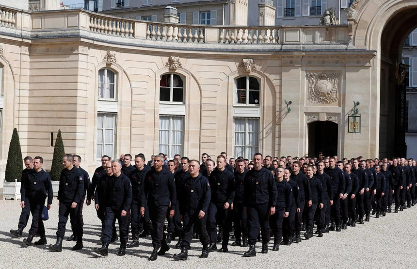 Các nhân viên cứu hộ rời Cung điện Elysee ở Paris sau cuộc gặp với Tổng thống Pháp Emmanuel Macron. Ông Macron cũng ca ngợi những người đóng vai trò ẩn giấu, chẳng hạn nhân viên của bộ văn hóa, người cất giữ và bảo quản cẩn thận các đồ tạo tác và nhân viên Hội Chữ thập đỏ đã đưa người dân địa phương thoát khỏi nguy hiểm và túc trực ở bệnh viện lân cận phòng trường hợp cần sơ tán. Ảnh: AP.