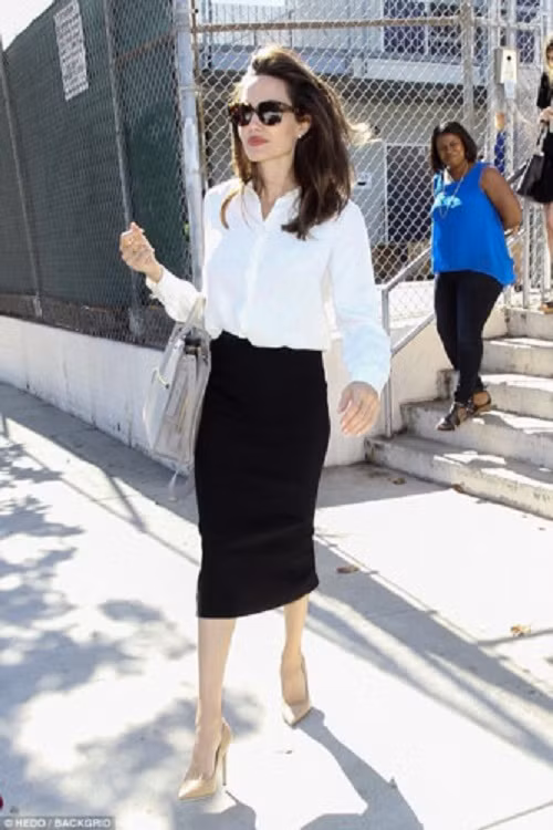 Ngôi sao kỳ cựu Hollywood diện chân váy bút chì trang nhã, áo sơmi trắng đơn giản cùng giày cao gót màu nude. Cô khoác túi cùng màu giày, đeo kính râm đơn giản.