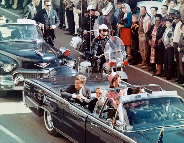 Vào ngày 22/11/1963, Tổng thống John F. Kennedy bị ám sát khi có mặt tại thành phố Dallas, tiểu bang Texas, Mỹ. Ngay sau khi xảy ra vụ việc gây chấn động nước Mỹ, Lee Harvey Oswald – kẻ tình nghi số 1 bị bắt ngay sau đó, và bị buộc tội gây ra ám sát khiến Tổng thống Kennedy tử vong.