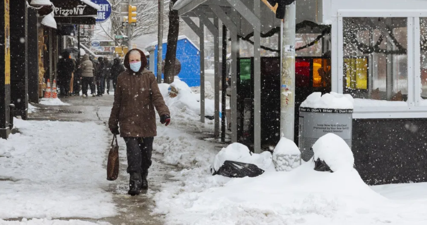 Người dân đi bộ dưới trời mưa tuyết ở khu Hell's Kitchen, New York.